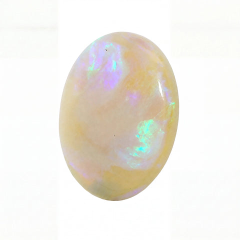 A polished oval cabochon opal gemstone displaying a soft cream base with iridescent flashes of purple, blue, and green, set against a plain white background.