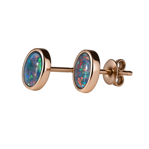 Gold earrings with opal stones on a white background