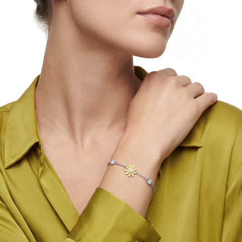 Woman wearing a bracelet with a sunflower charm on a white background