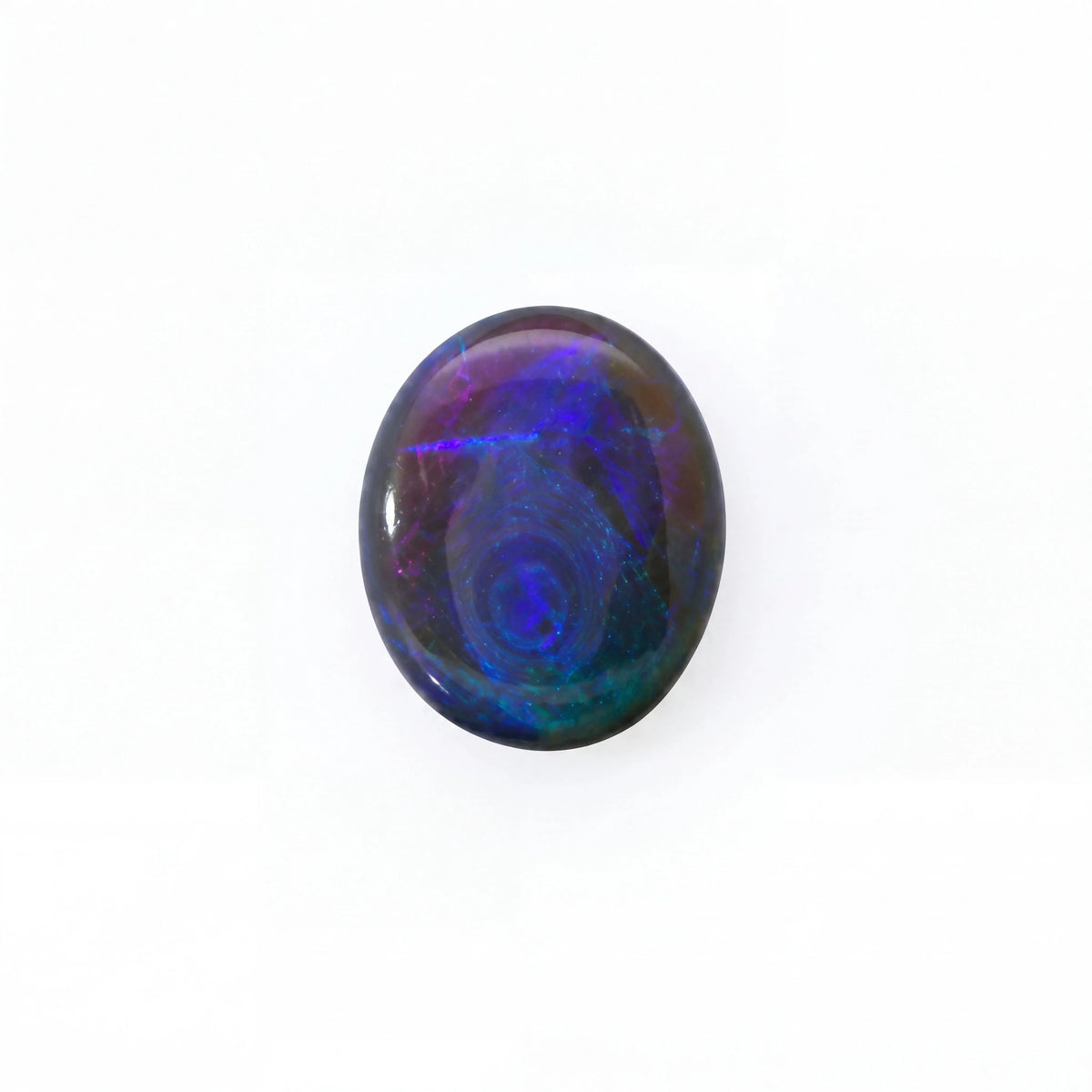 A polished oval cabochon gemstone displaying vibrant iridescent play-of-colour with swirling patterns of blue, purple, and green on a white background.