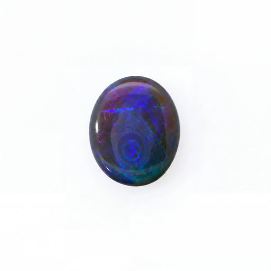 A polished oval cabochon gemstone displaying vibrant iridescent play-of-colour with swirling patterns of blue, purple, and green on a white background.