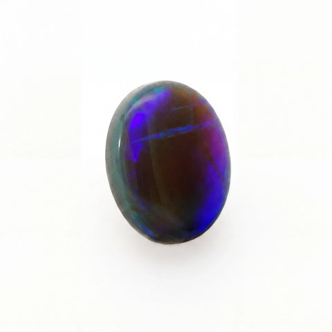 A polished oval cabochon gemstone displaying vibrant iridescent play-of-colour with deep blue, purple, and green hues over a dark brown base, set against a plain white background.