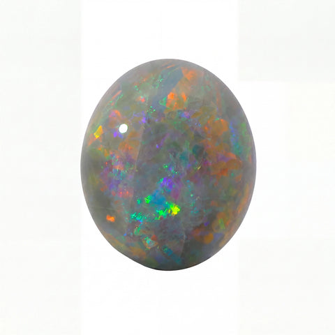 A polished oval cabochon opal gemstone displaying a play-of-colour with iridescent flashes of green, orange, blue, and purple on a dark grey base, set against a plain white background.