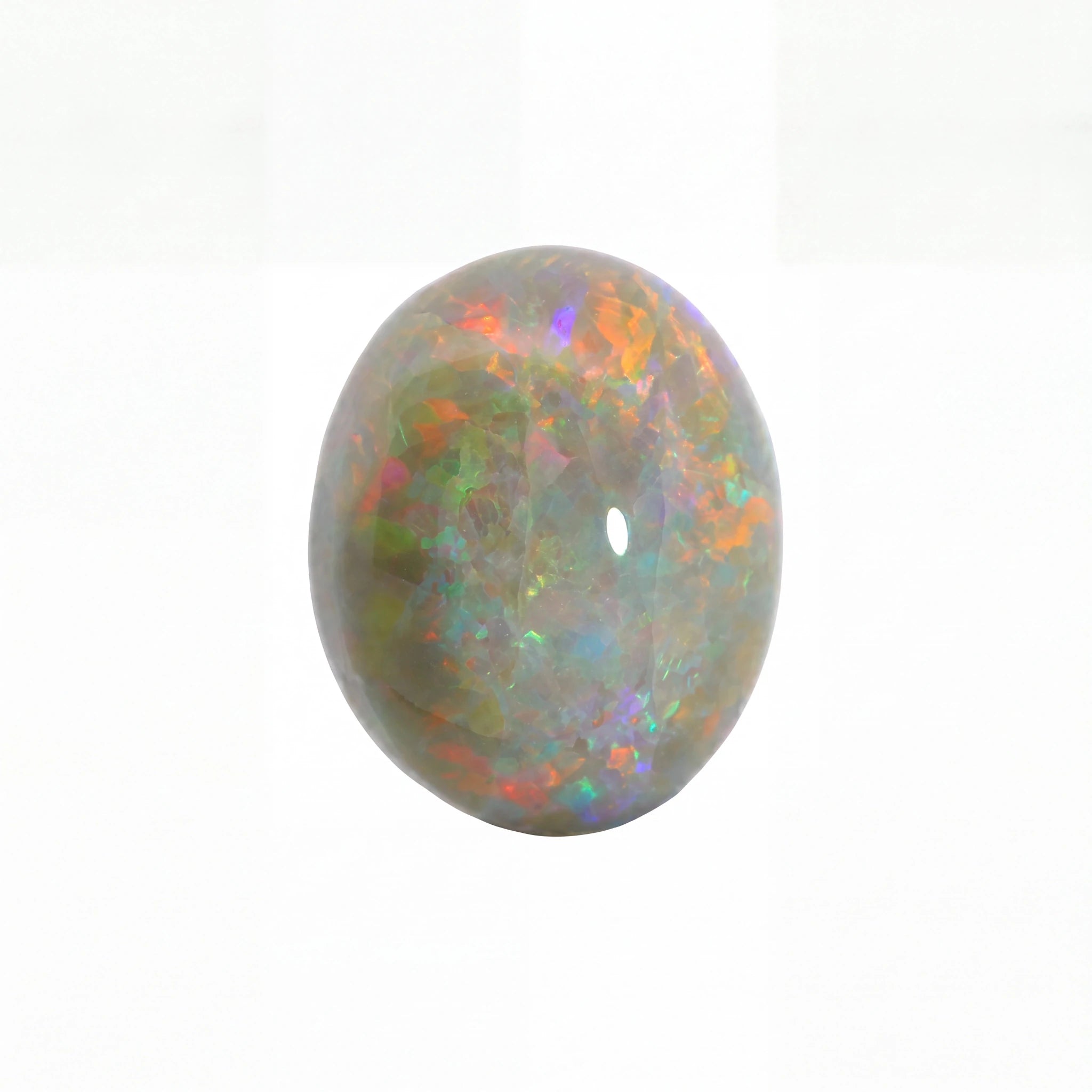 A polished oval cabochon gemstone with a play-of-colour pattern featuring green, orange, purple, and blue iridescence on a white background.