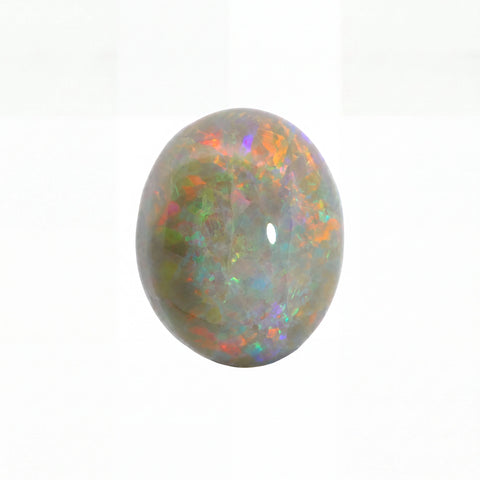 A polished oval cabochon gemstone with a play-of-colour pattern featuring green, orange, purple, and blue iridescence on a white background.
