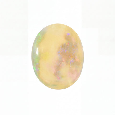 A polished oval cabochon gemstone featuring a creamy yellow base with iridescent flashes of green, blue, and pink, set against a plain white background.