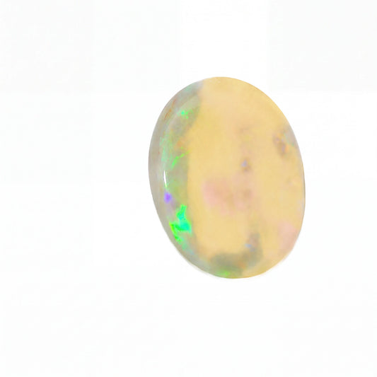 A polished oval cabochon gemstone showing a creamy yellow base with iridescent flashes of green, blue, and pink, set against a plain white background.