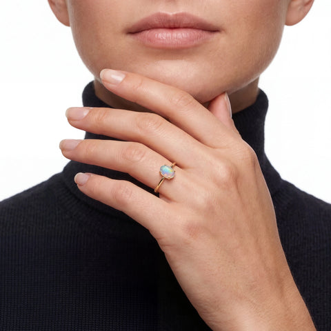 Close-up of a hand wearing an opal ring 