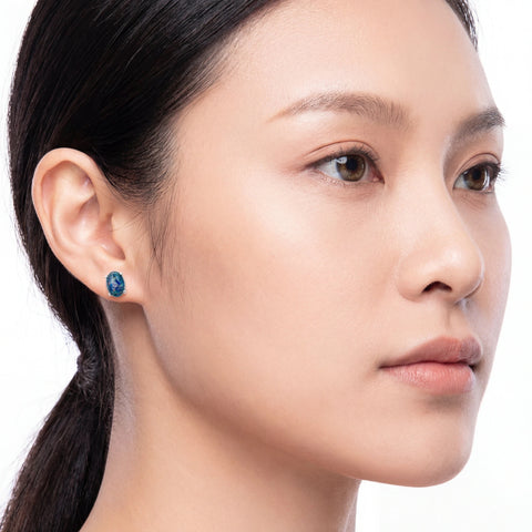 Close-up of a woman wearing a blue earring on a white background