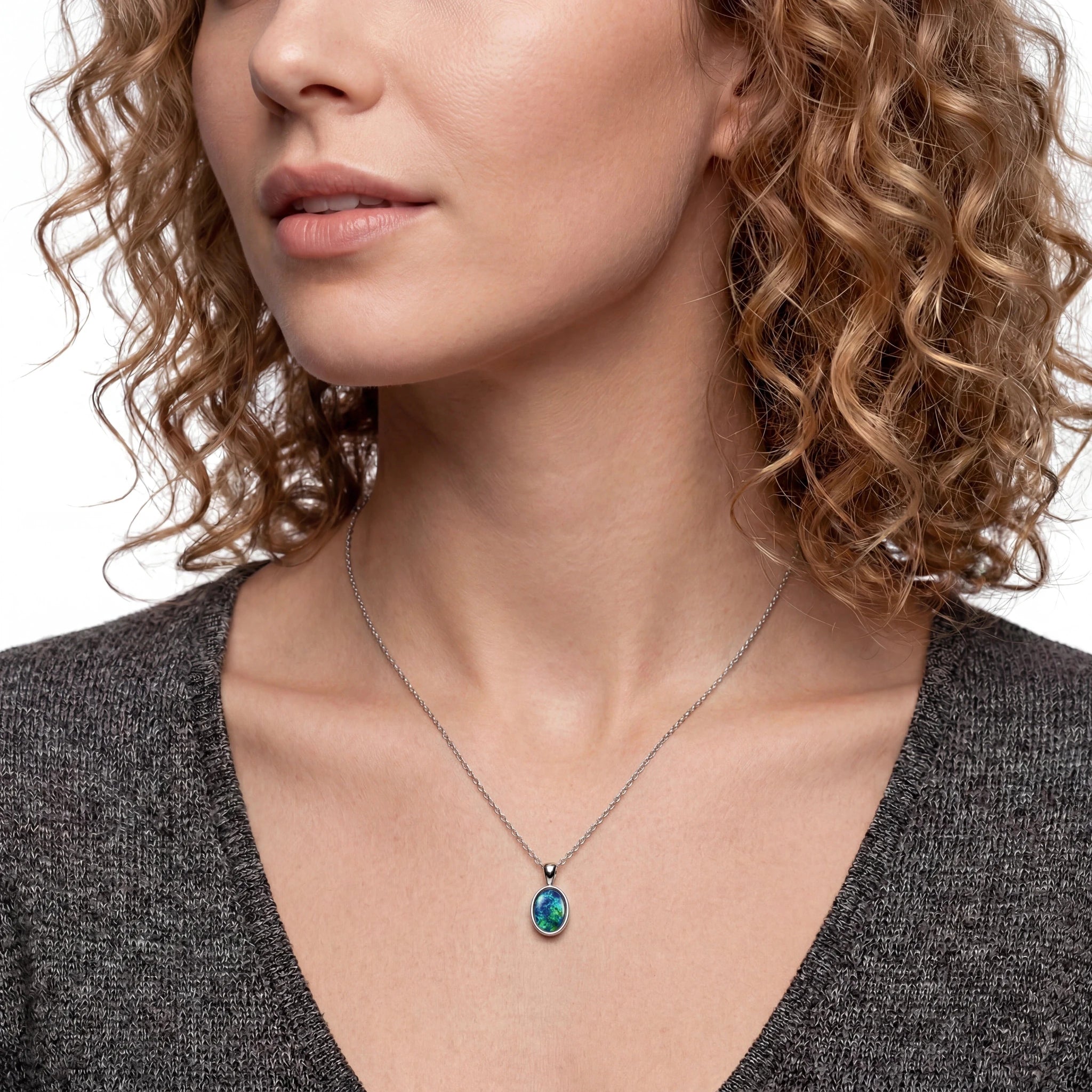 Close-up of a woman wearing a necklace with a pendant.