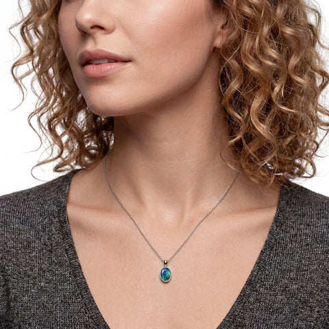 Close-up of a woman wearing a necklace with a pendant.