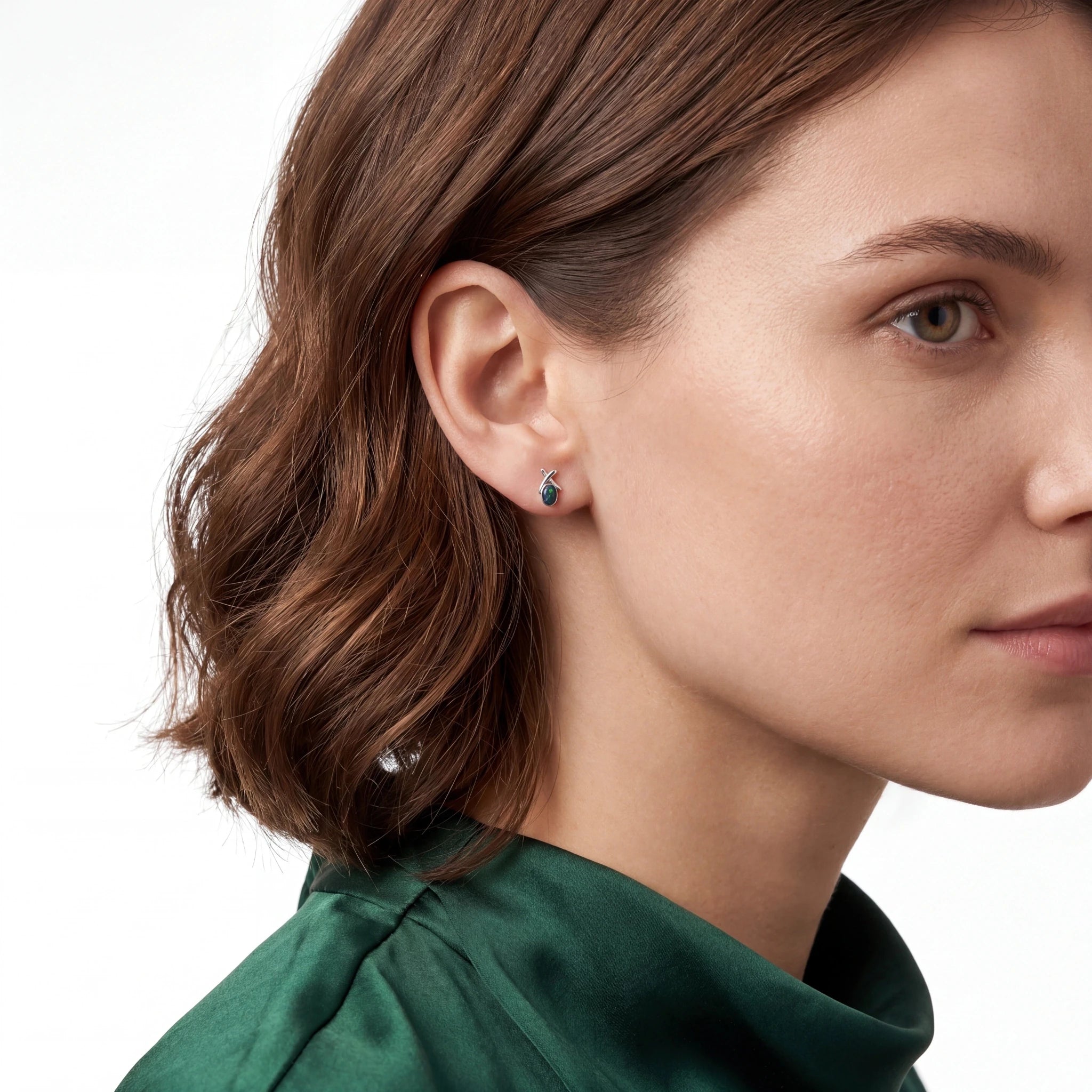 Close-up of a woman wearing earrings with a plain background