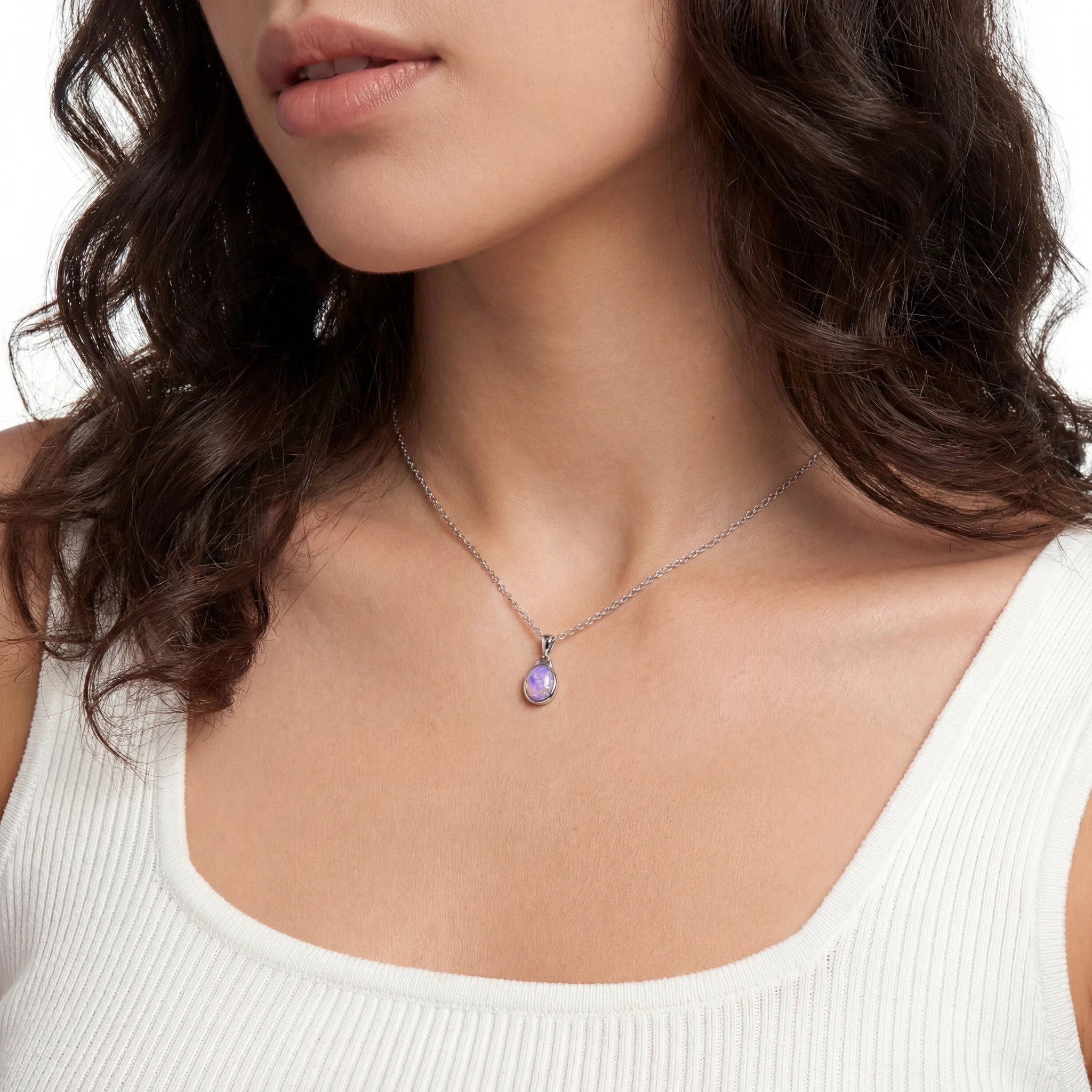 Woman wearing a necklace with a purple pendant on a neutral background