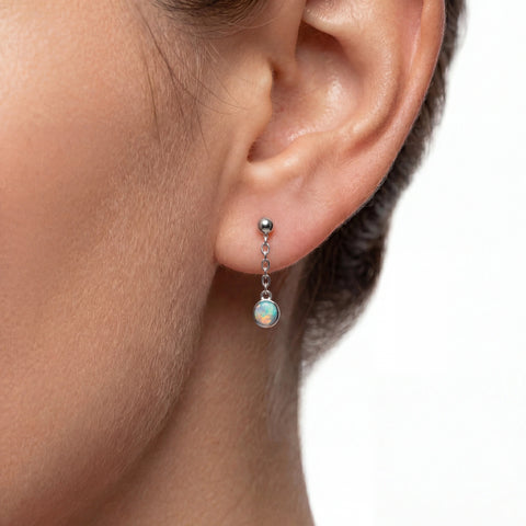 Close-up of an ear wearing a small earring with a white background