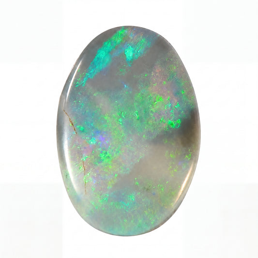 Oval-shaped opal stone with green and blue fluorescence on a white background