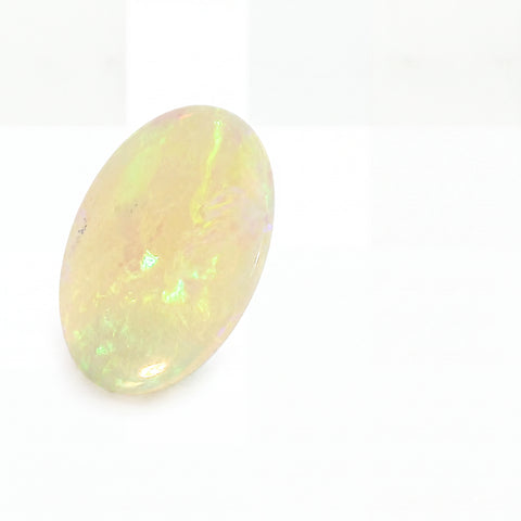 Oval-shaped opal gemstone on a white background