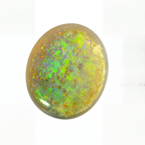 Round opal stone with green and yellow fluorescence on a white background
