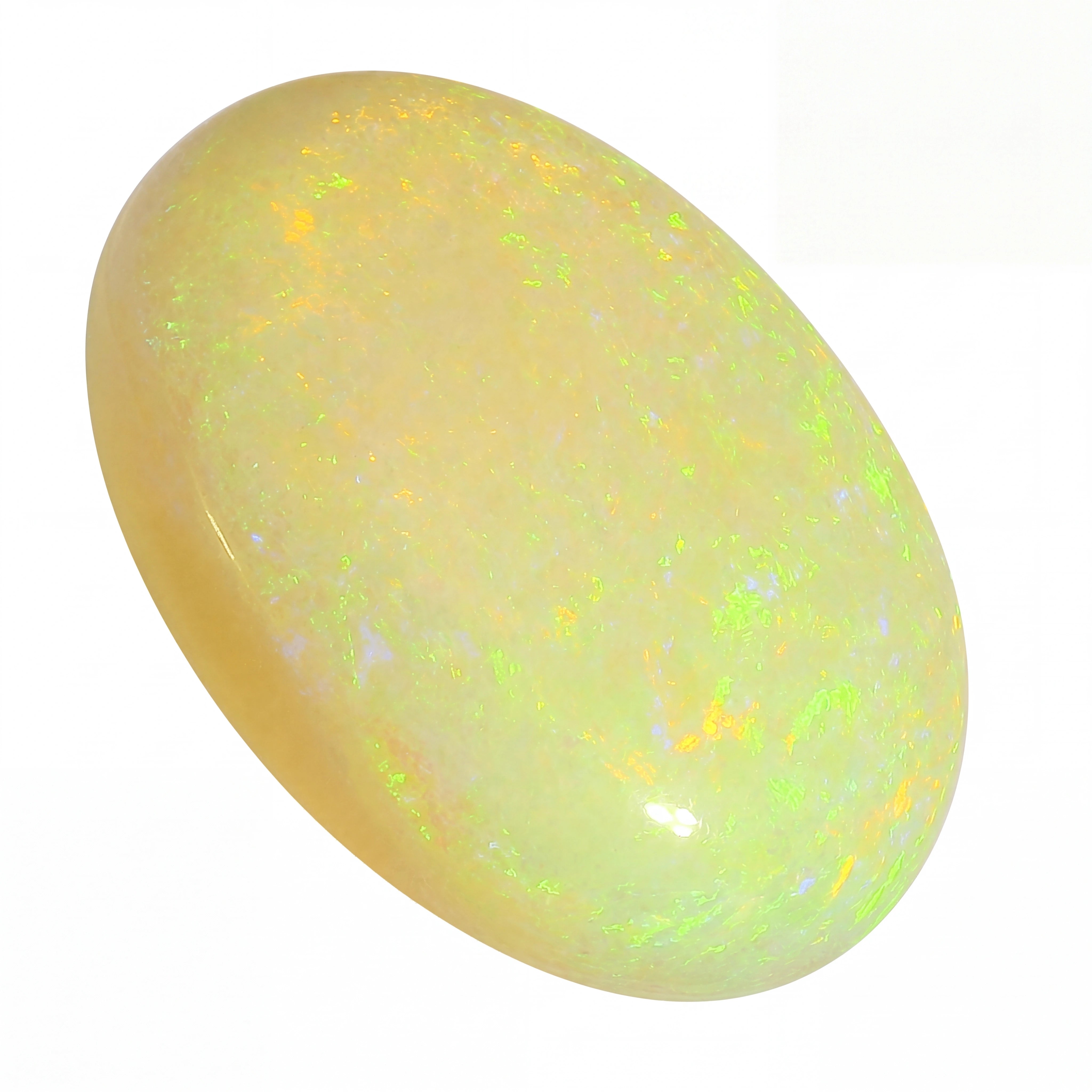 Opal stone with a yellowish hue and speckled pattern on a white background