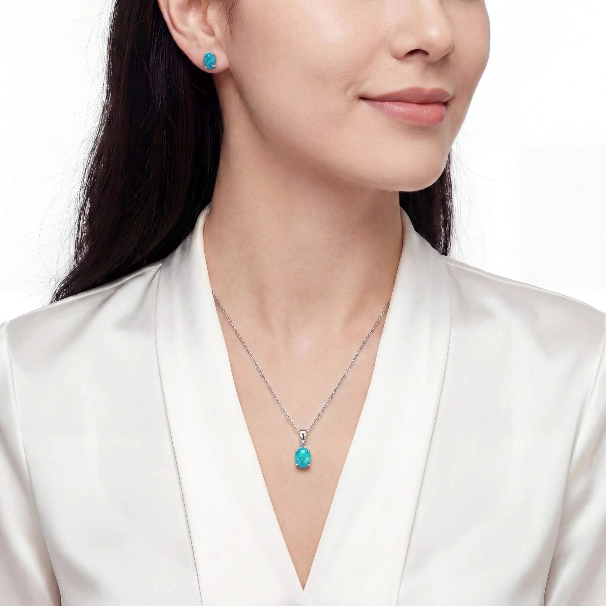 Woman wearing a turquoise pendant necklace and earrings on a white background