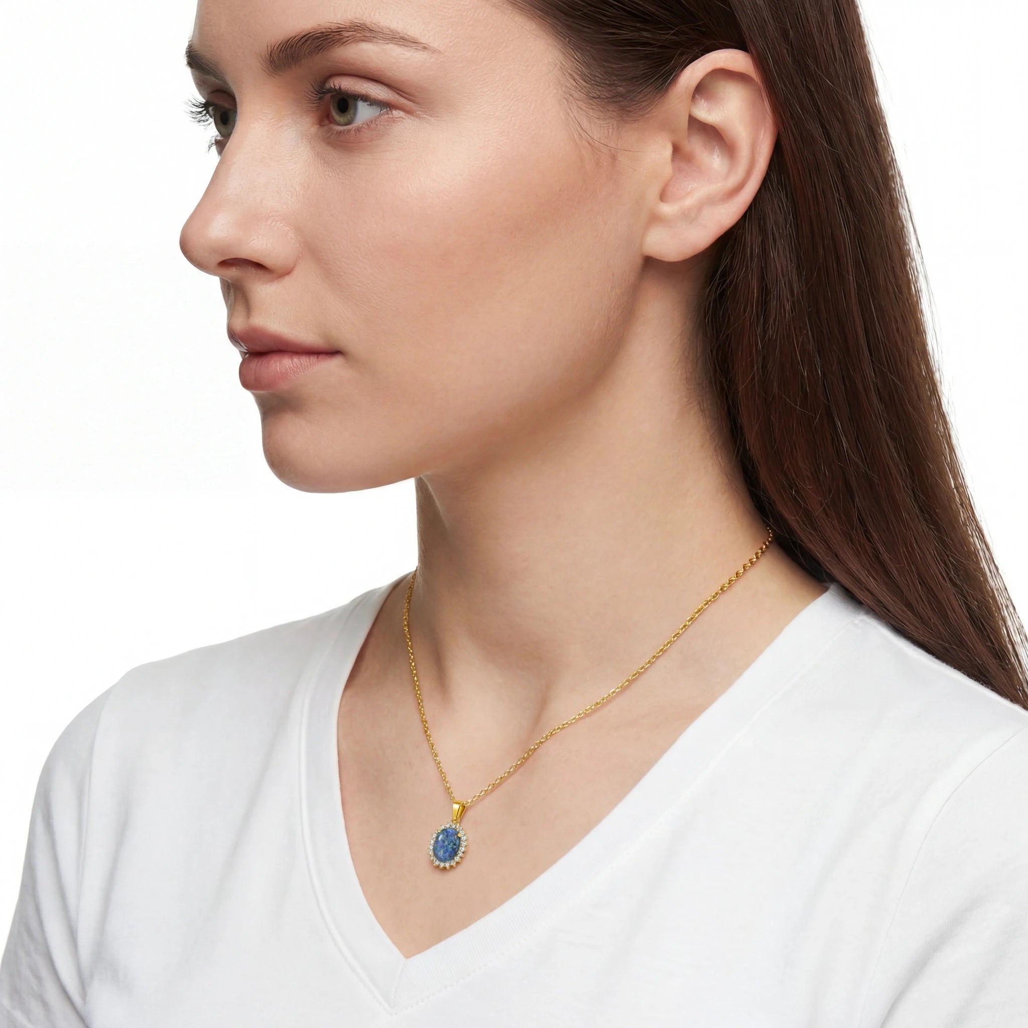 Woman wearing a gold necklace with a blue pendant on a white background