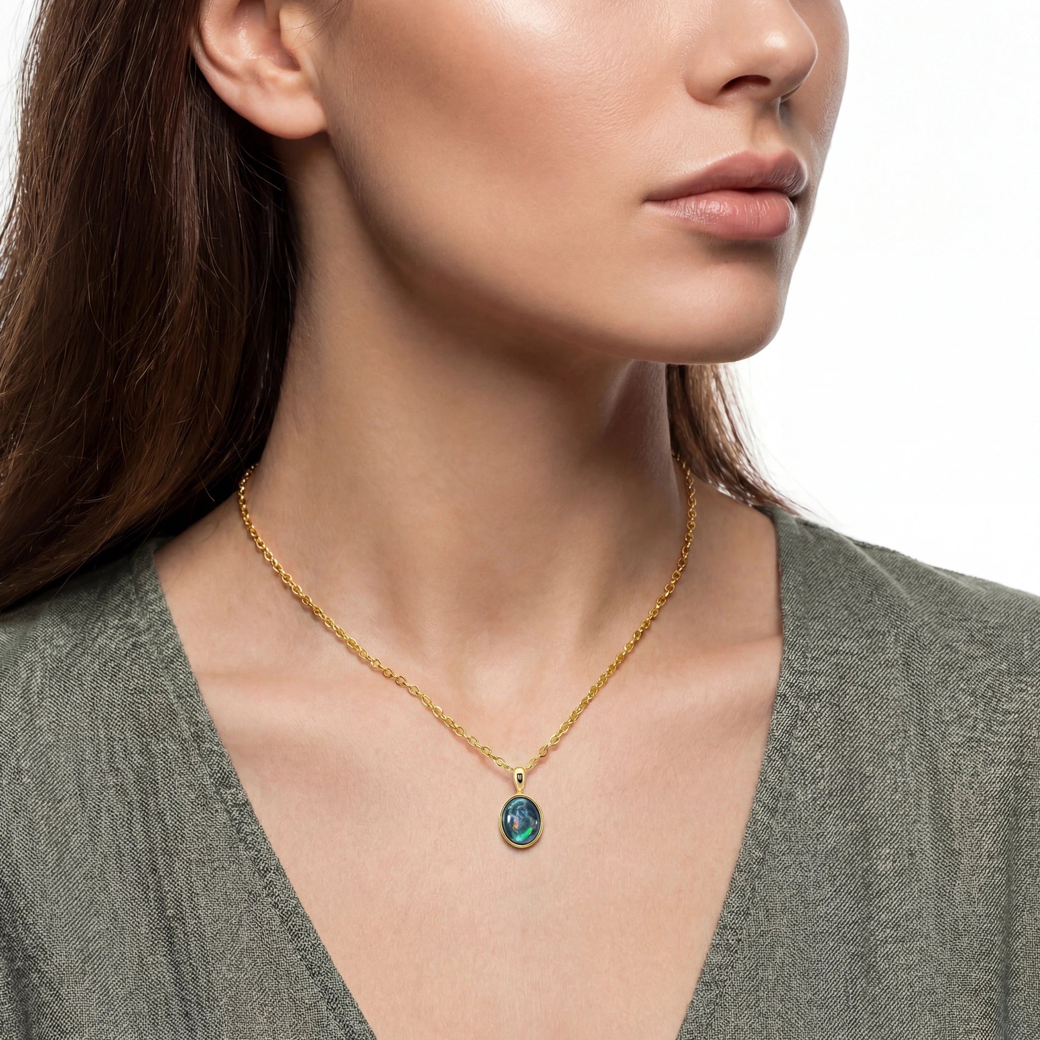 Close-up of a woman wearing a gold necklace with a pendant on a white background