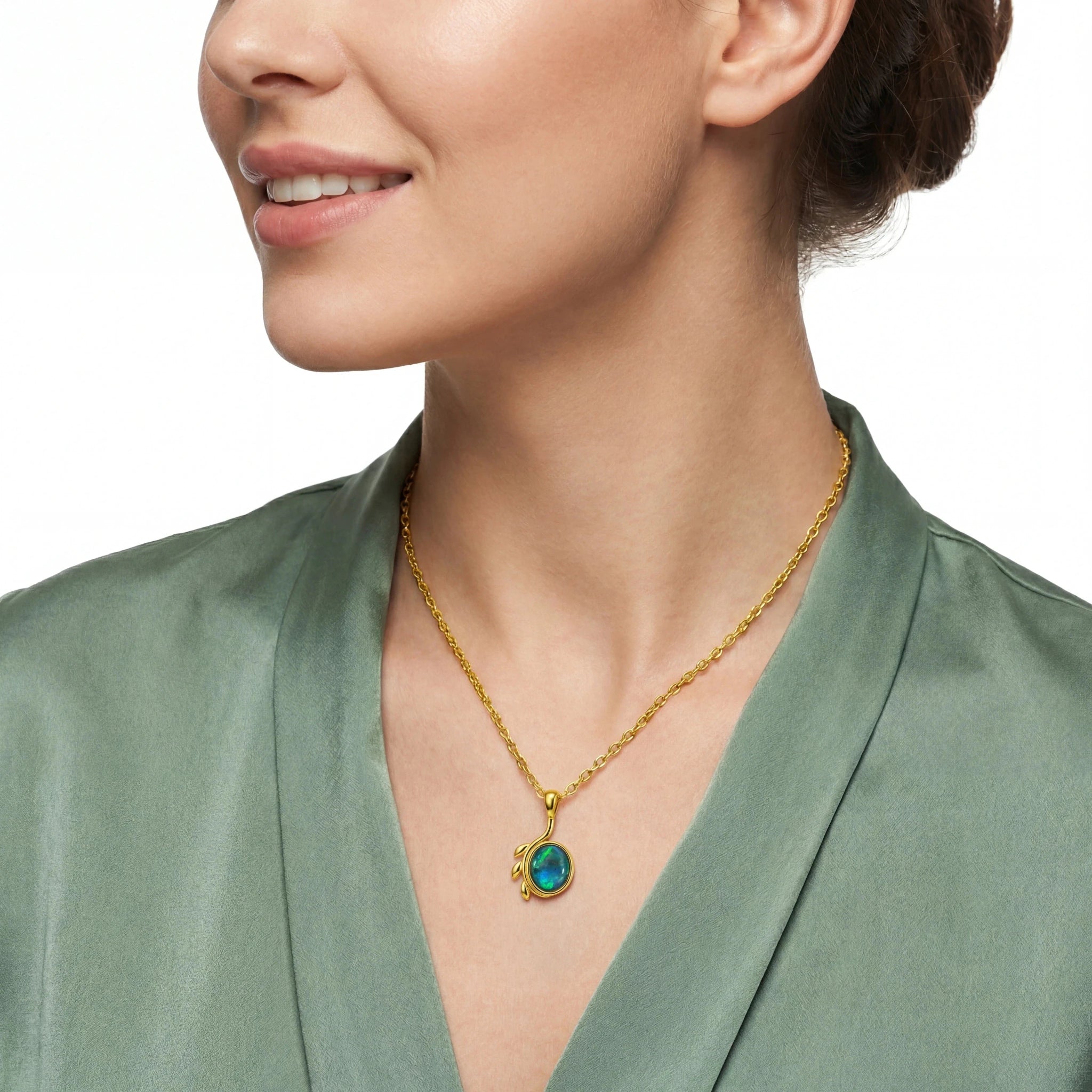 Woman wearing a gold necklace with a green pendant on a white background