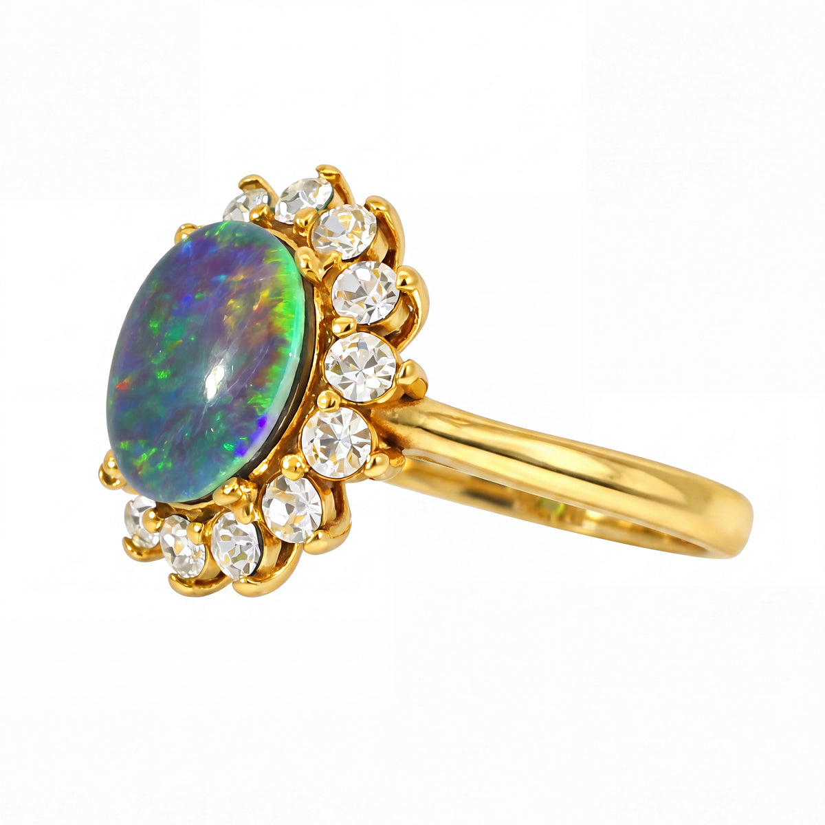 Gold pendant with an opal stone and clear gemstones on a white background