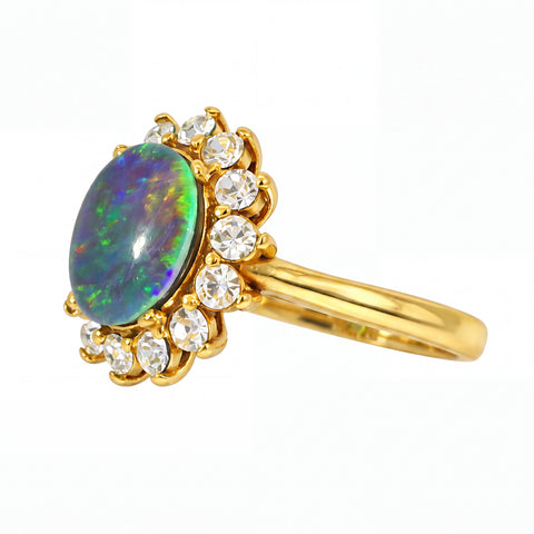 Gold pendant with an opal stone and clear gemstones on a white background