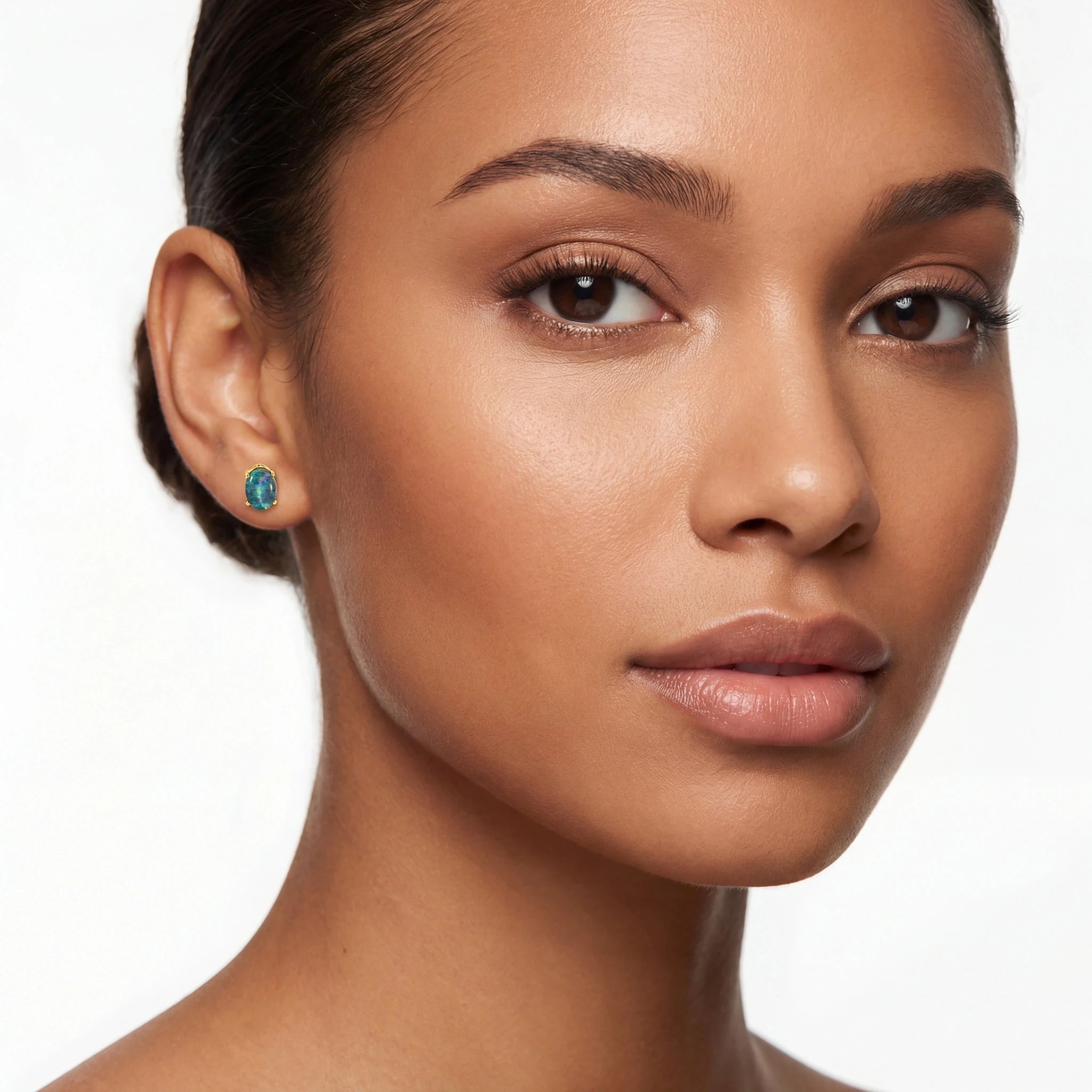 Close-up of a woman wearing turquoise earrings on a white background