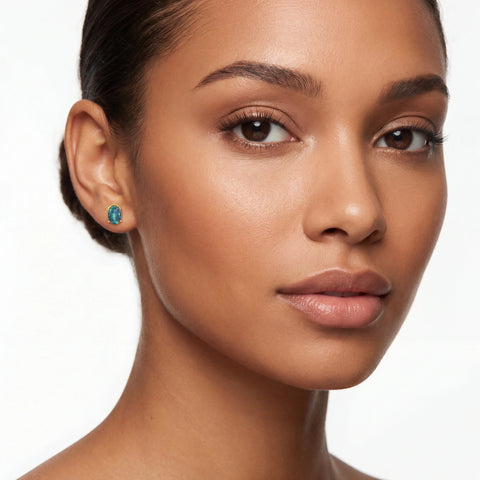 Close-up of a woman wearing turquoise earrings on a white background