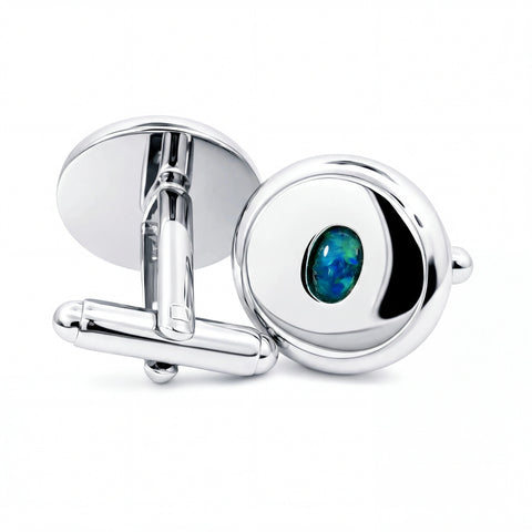 Silver cufflinks with a central green gemstone on a white background
