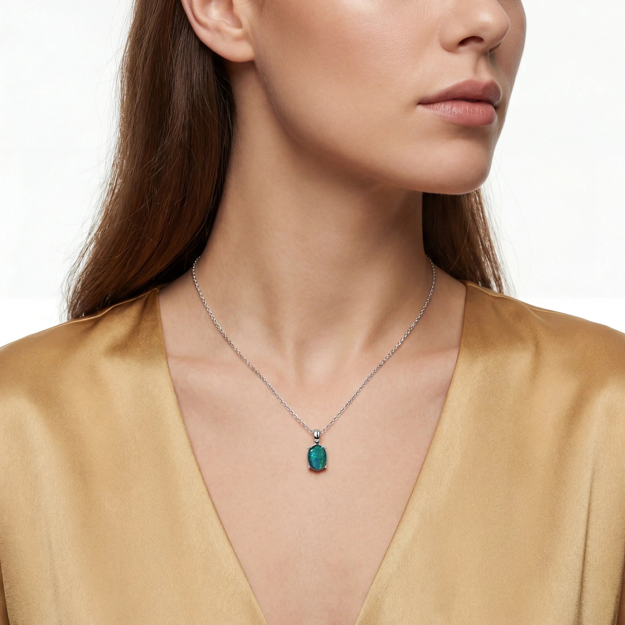 Woman wearing a necklace with a green pendant on a white background