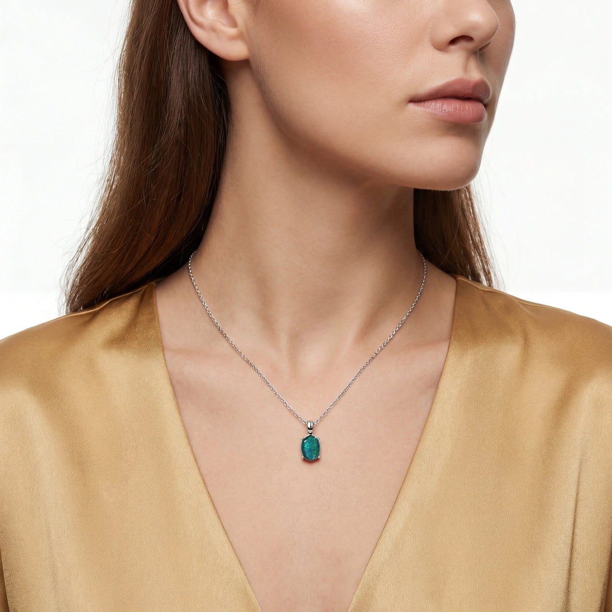 Woman wearing a necklace with a green pendant on a white background