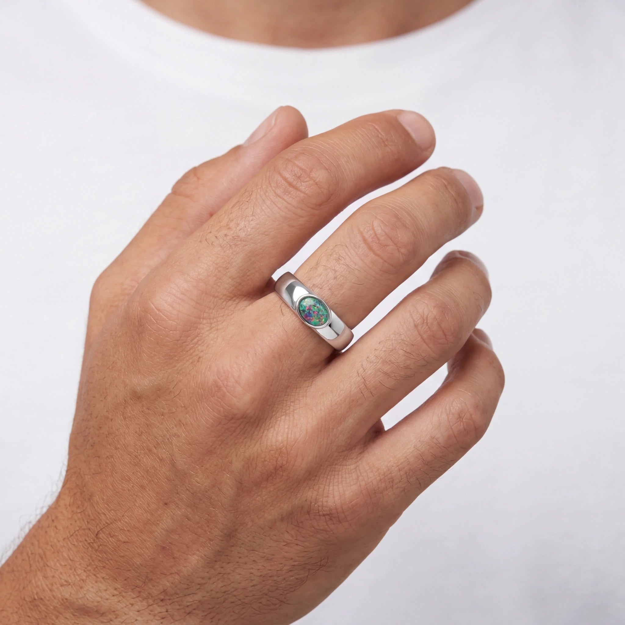 Man wearing a silver ring with a green opal gemstone