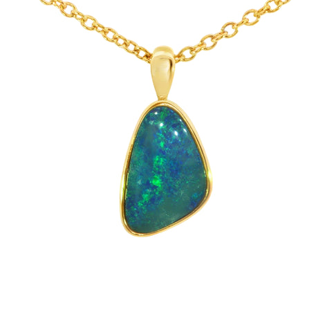 Gold pendant with a green gemstone on a white background
