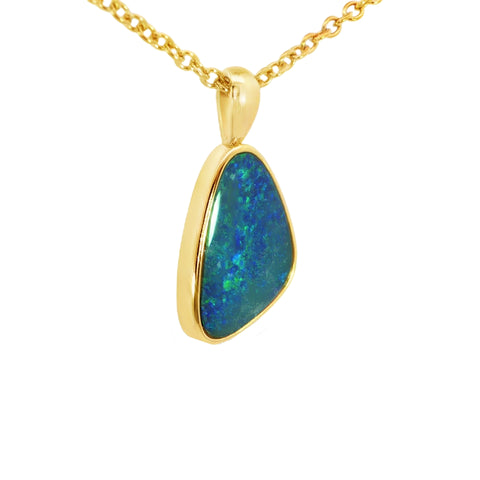 Gold pendant with a blue-green stone on a white background