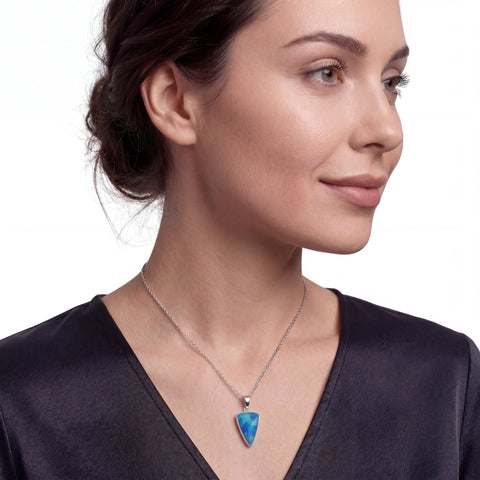 Woman wearing a necklace with a blue pendant on a white background