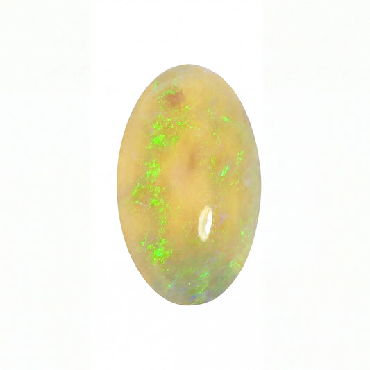 An oval cabochon opal gemstone with a warm golden-beige base and vibrant green flashes, shown on a plain white background.