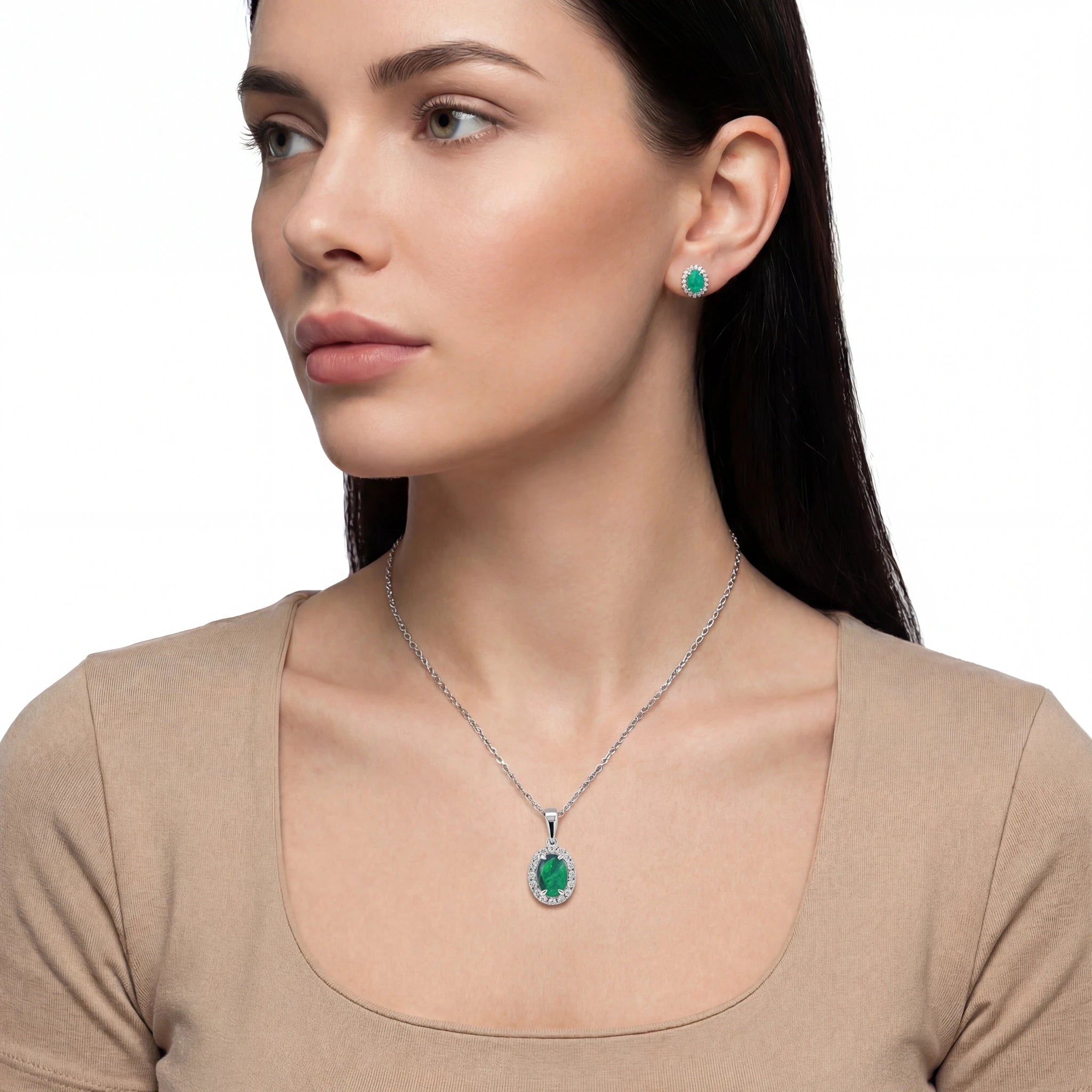 Woman wearing a green gemstone necklace and earrings on a white background