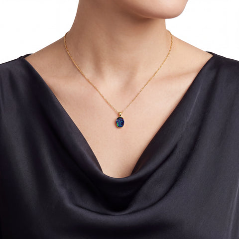 Woman wearing a gold necklace with a pendant on a white background