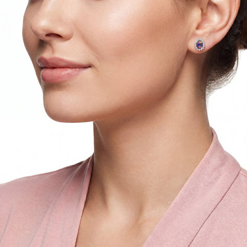 Close-up of a woman wearing a pair of earrings with a pink top.