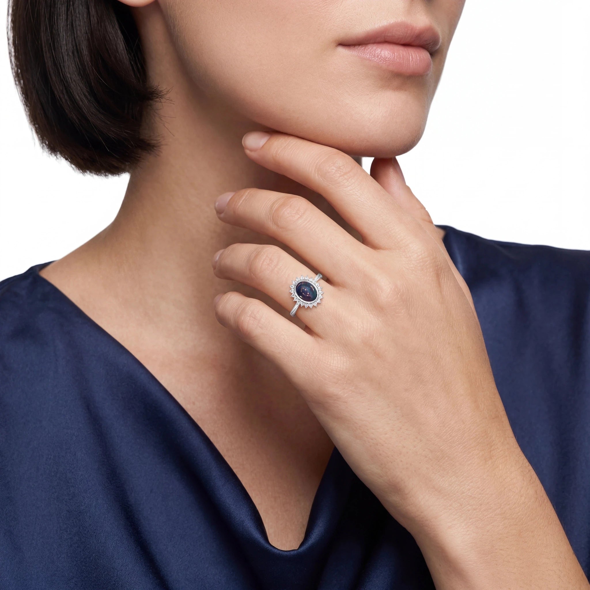 Close-up of a woman wearing a silver ring with a blue opal gemstone