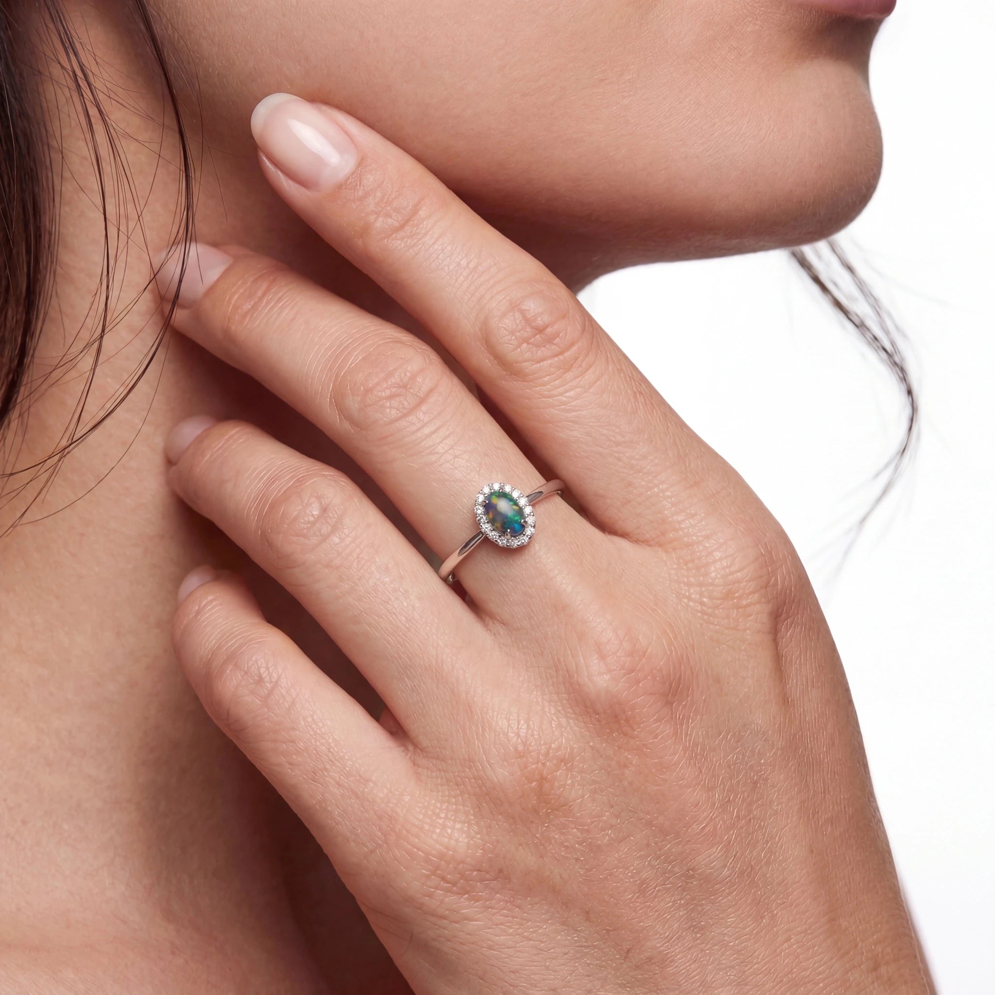 Close-up of a woman wearing a ring with a green opal gemstone