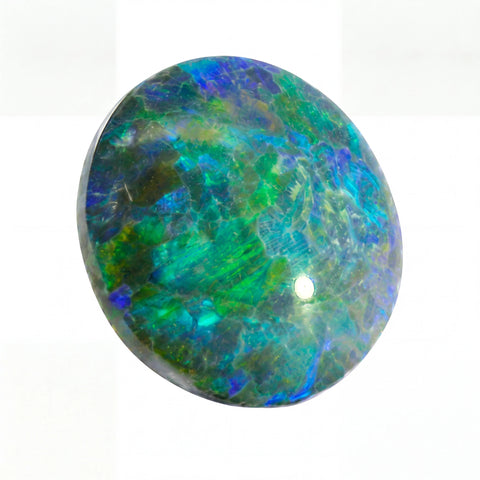 Round opal stone with multicoloured patterns on a white background