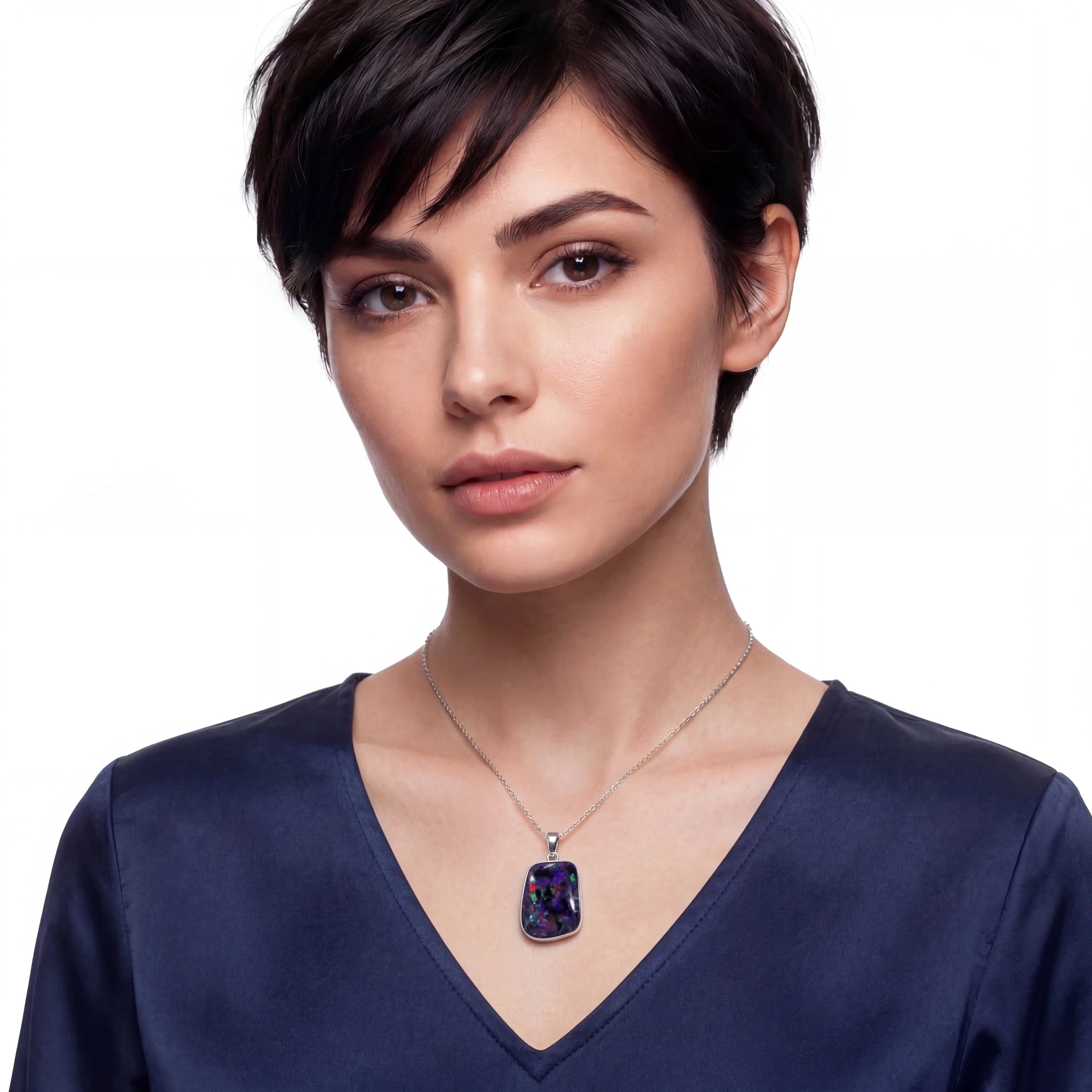 Woman wearing a necklace with a dark blue pendant on a white background