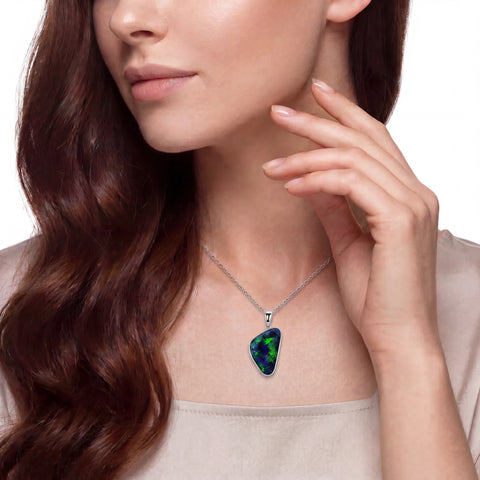 Woman wearing a necklace with a green pendant on a white background