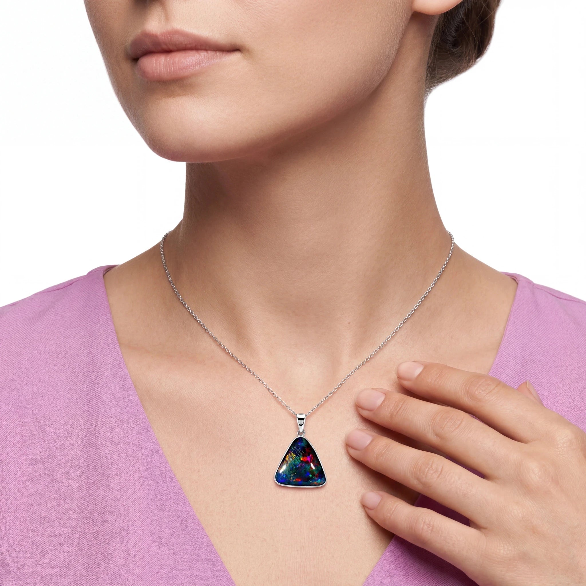 Person wearing a necklace with a colourful pendant on a white background