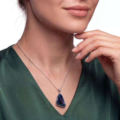 Necklace with a colourful pendant worn by a person against a white background