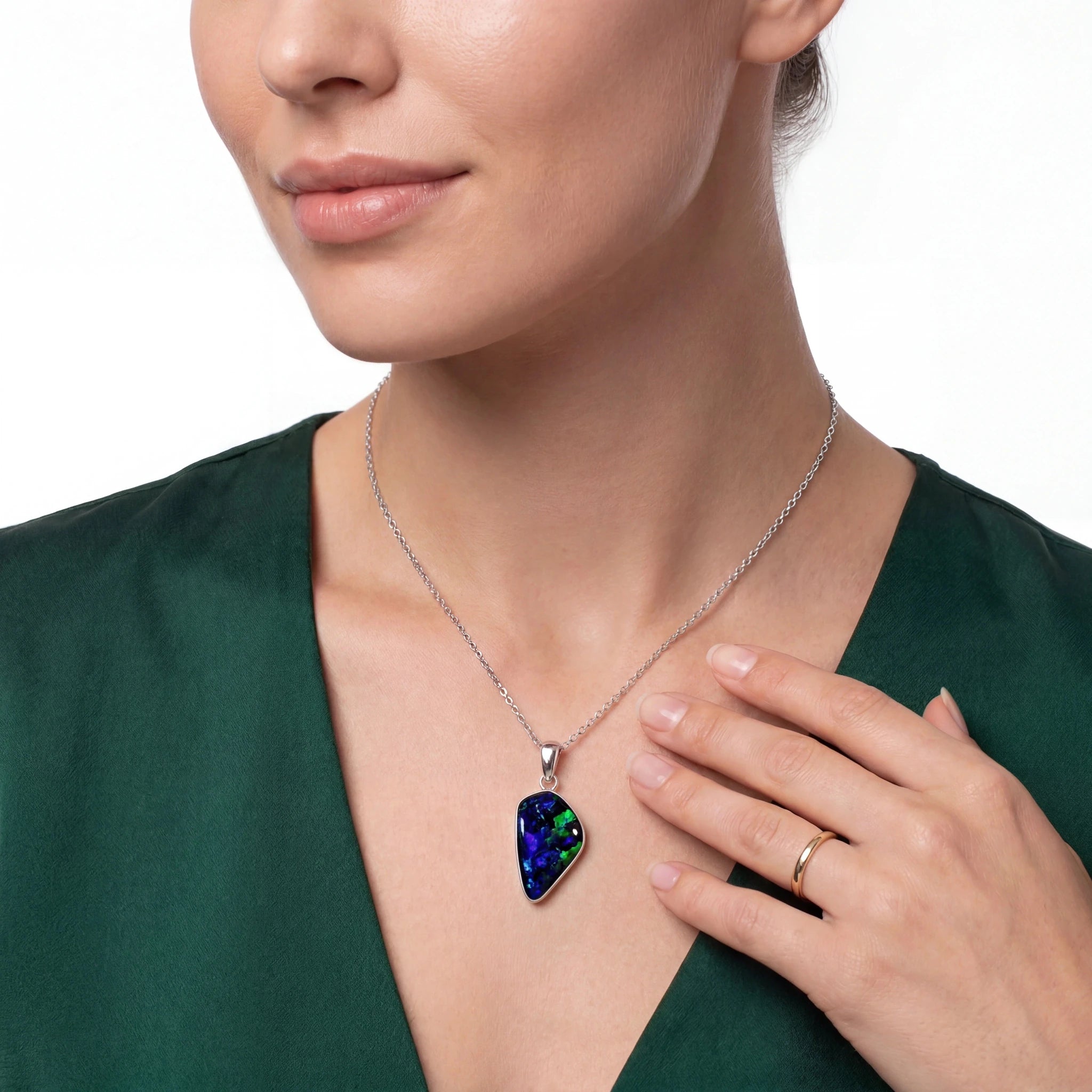 Woman wearing a necklace with a colourful pendant against a white background