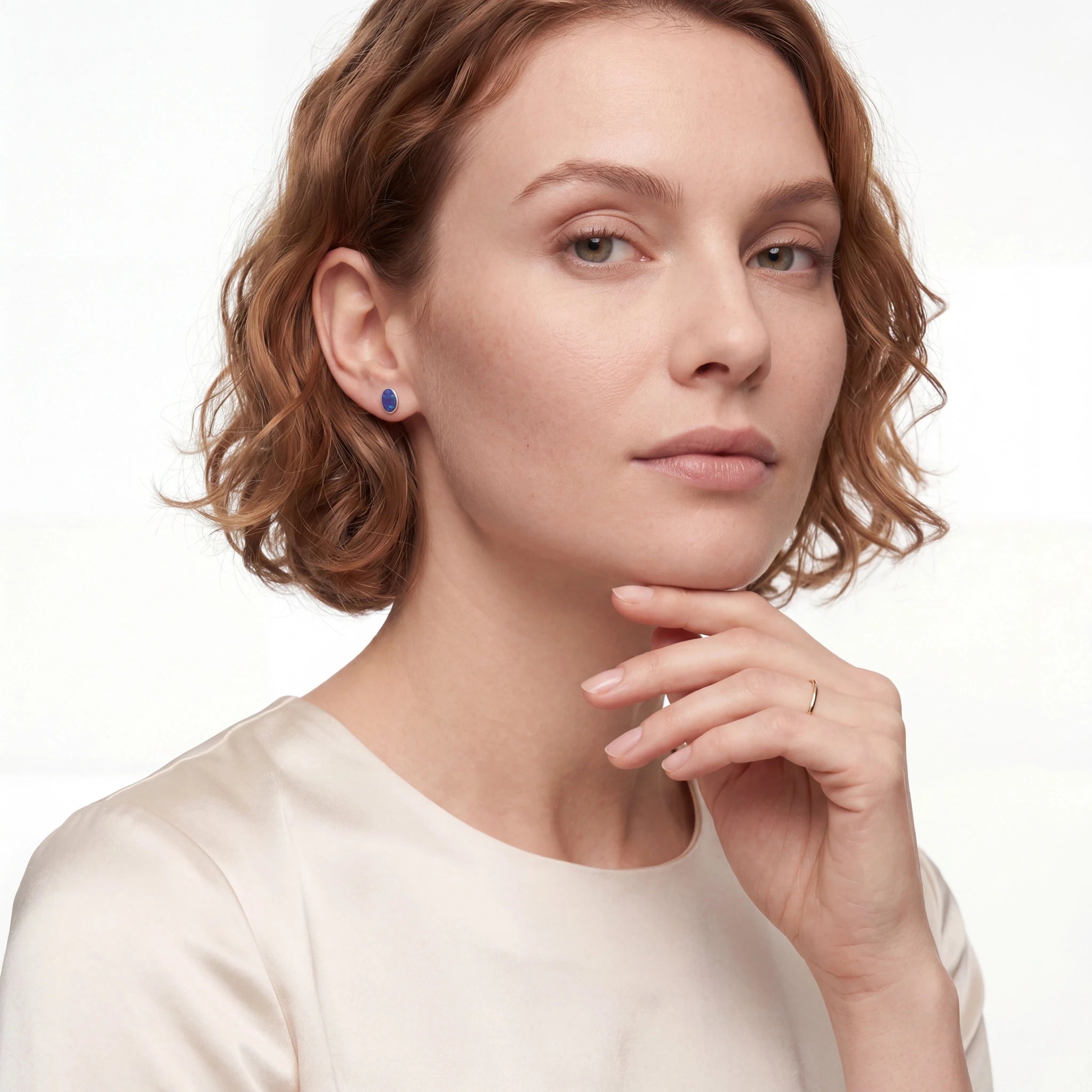Woman wearing a blue earring on a white background